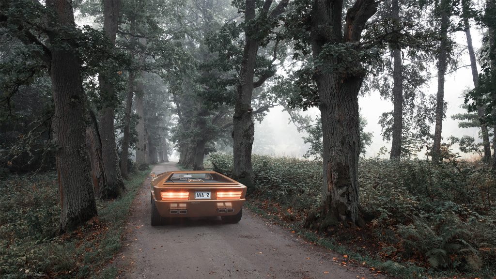 A copper coloured Maserati Boomerang driving on a narrow gravel road surrounded with big old oak trees on a foggy morning.